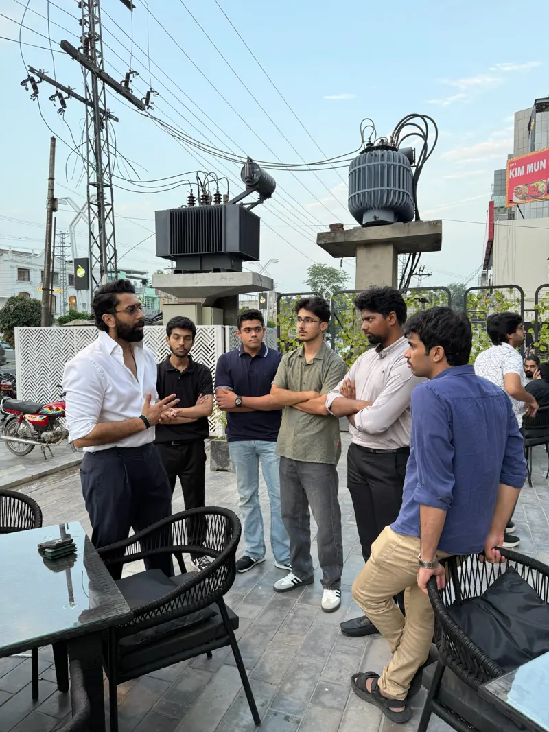 A speaker talking with a circle of guests on the terrace outside