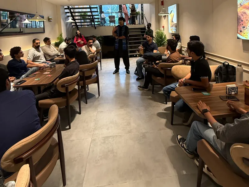 Guests at UnMixer seated around tables while a speaker talks