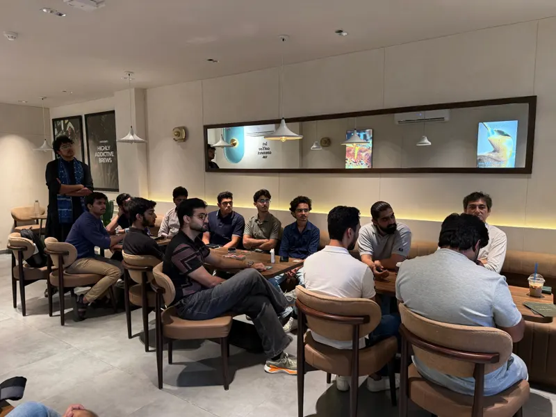 Guests seated with cards on the tables while Faseeh stands at the back